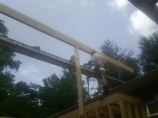 Carpenter setting a ridge beam over a new addition frame — Ice Dam Removal by Roofing Brothers in New Hyde Park