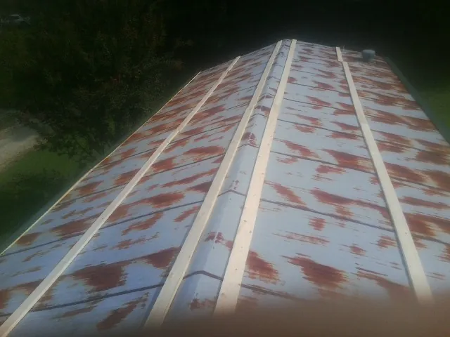 Rusted metal roof panels with new wood purlins before replacement — Storm Damage Roof Repair in New Hyde Park by Roofing Brothers