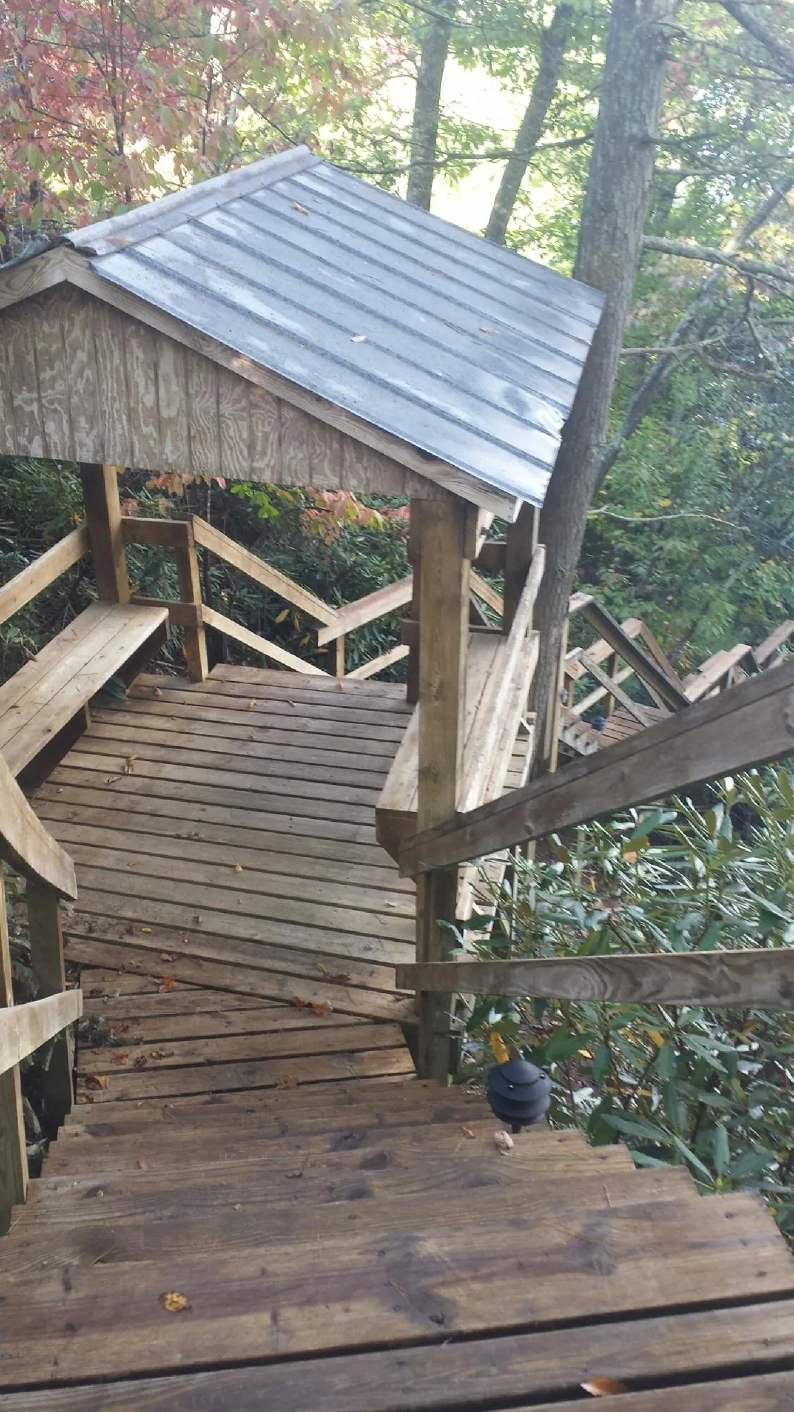 Metal roofed shelter over wooden steps on a wooded walkway — Skylight Repair & Installation work by our crew in New Hyde Park