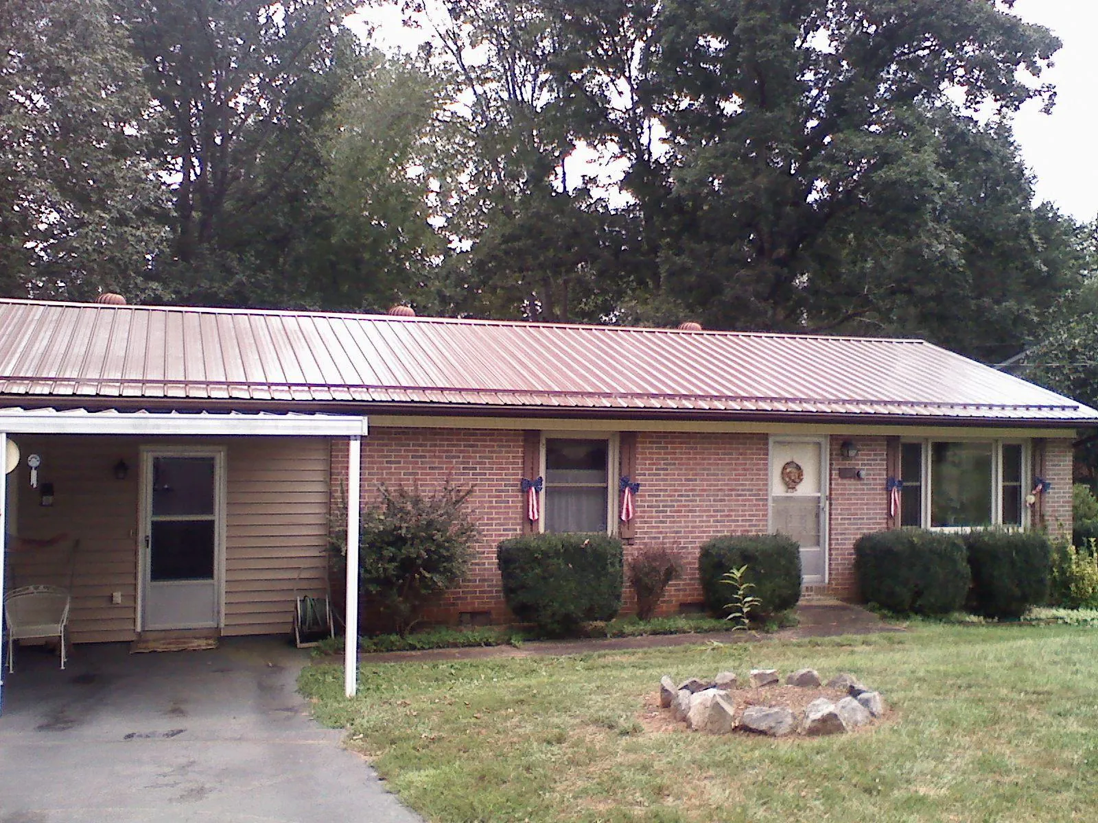 Bronze metal roof and carport on a brick ranch home — Roof Repair work by our crew in New Hyde Park